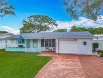 Charming single-story home with a brick driveway, manicured lawn and an attached garage at 805 E 15Th Ave, New Smyrna Beach, FL 32169