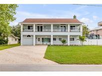 Charming two-story home with a large front yard and a spacious two-level balcony at 90 Cunningham Dr, New Smyrna Beach, FL 32168