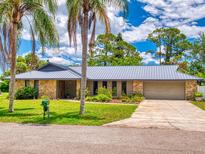 Charming home featuring a stone facade, metal roof, and well-manicured landscaping at 108 Dee St, New Smyrna Beach, FL 32168