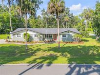 Charming single-story home with manicured lawn and mature trees at 1144 Corbin Park Rd, New Smyrna Beach, FL 32168