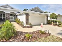 Charming home exterior with a two-car garage, stone accents, and well-maintained landscaping at 1442 Carlow Cir, Ormond Beach, FL 32174
