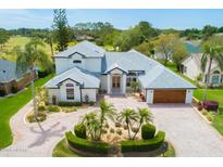 Stunning home featuring a circular driveway, lush landscaping, attached garage, and manicured lawn at 2005 Country Club Dr, Port Orange, FL 32128