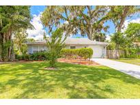 Charming home with mature landscaping, a well-manicured lawn, and a welcoming driveway at 3120 Mango Tree Dr, Edgewater, FL 32141
