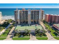 Stunning oceanfront condo building featuring a tennis court, lush landscaping, and breathtaking ocean views at 4139 S Atlantic Ave # A302, New Smyrna Beach, FL 32169