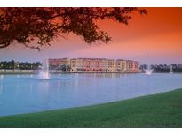 Beautiful waterfront community with fountains and lush green lawn against a colorful sunset sky at 424 Luna Bella Ln # 316, New Smyrna Beach, FL 32168