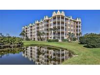 Upscale condo building with multiple balconies reflected in a pond on a sunny day at 4620 Riverwalk Village Ct # 7306, Ponce Inlet, FL 32127