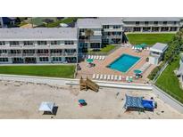 Aerial view of beachfront condo complex with pool, beach access, and well-maintained green spaces at 4849 Saxon # C202, New Smyrna Beach, FL 32169