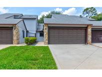 Charming townhome featuring a private two-car garage, stone accents, and a well-maintained lawn at 488 Shorewood Ln, New Smyrna Beach, FL 32168