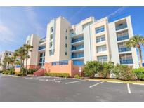 Bright multi-story condo building featuring colorful accents, well-maintained landscaping, and ample parking at 5300 S Atlantic Ave # 1-603, New Smyrna Beach, FL 32169