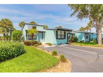 Charming aqua-colored villa with well-manicured landscaping and a private parking space at 76 Heather Point Ct, New Smyrna Beach, FL 32169