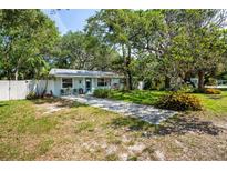 Charming single story home with front yard, lush trees, and inviting seating area at 804 E 12Th Ave, New Smyrna Beach, FL 32169
