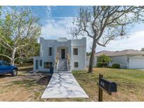 Striking two-story home featuring a unique facade, well-manicured lawn, and inviting front entryway with a modern mailbox at 833 E 12Th Ave, New Smyrna Beach, FL 32169