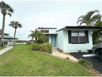 Charming coastal home with lush landscaping, palm trees, and a peek of the water nearby at 84 Heather Point Ct, New Smyrna Beach, FL 32169