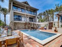Spacious backyard with a private pool, outdoor dining area, and comfortable seating perfect for relaxation at 1421 N Atlantic Ave, New Smyrna Beach, FL 32169