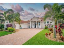 Beautiful home featuring manicured landscaping, tile roof, brick drive, and a three-car garage at 150 Portofino Blvd, New Smyrna Beach, FL 32168