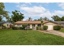 Charming single-story home with a well-manicured lawn, lush landscaping, and inviting curb appeal at 210 Delespine Dr, Debary, FL 32713