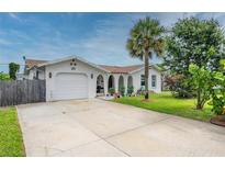 Quaint single-story home featuring a barrel tile roof, stucco finish, and well-manicured yard with mature landscaping at 25 Dolphin Ave, Ormond Beach, FL 32176