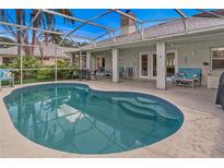 Enjoy this kidney shaped pool with a screened-in lanai and lounge seating at 2632 Turnbull Estates Dr, New Smyrna Beach, FL 32168