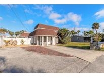 Inviting two-story home featuring a brick driveway, mature landscaping and a unique covered entryway at 2900 S Peninsula Dr, Daytona Beach, FL 32118