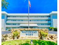 Waterway West building features an American flag, manicured grounds, and is conveniently located near shopping and amenities at 315 N Causeway # 2060, New Smyrna Beach, FL 32169