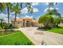 Beautiful single-story home with lush landscaping and a circular driveway with decorative brick accents at 3577 Maribella Dr, New Smyrna Beach, FL 32168