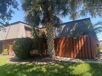 Charming townhouse with a well-maintained exterior featuring a privacy fence and lush tropical landscaping at 38 Cedar Dunes Dr, New Smyrna Beach, FL 32169