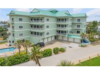 Stunning condominium exterior showcasing multiple balconies, a private pool, and ample parking at 423 S Atlantic Ave # 301, New Smyrna Beach, FL 32169