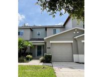 Charming multi-story townhouse showcasing a well-manicured lawn and a two-car garage at 511 Mount Olympus Blvd, New Smyrna Beach, FL 32168