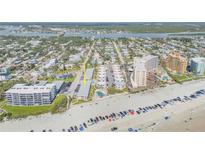Wide aerial view of a beachfront condominium complex with ocean views, tennis courts, and community pool at 525 N Atlantic Ave # 39, New Smyrna Beach, FL 32169