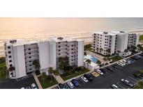 Stunning aerial view of beachfront condos with a pool and ample parking, providing resort-style living at 5301 S Atlantic Ave # 140, New Smyrna Beach, FL 32169