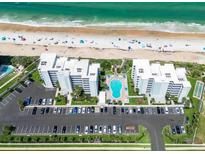 An aerial view of a beachfront condo community with a pool, parking, and easy beach access at 5301 S Atlantic Ave # 140, New Smyrna Beach, FL 32169