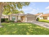 Charming single-story home with a well-manicured lawn, mature trees, and inviting curb appeal at 620 Middlebury Loop, New Smyrna Beach, FL 32168