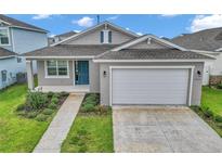 Charming single-story home with a two-car garage, blue door, and well-maintained landscaping at 7223 Sw 61St Pl, Ocala, FL 34474
