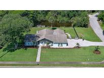 Beautiful single-story home featuring an expansive, well-maintained lawn and attractive landscaping near a tranquil pond at 798 Fairway Dr, New Smyrna Beach, FL 32168