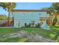Charming two-story home features a welcoming front entrance and lush landscaping at 934 N Halifax Ave, Daytona Beach, FL 32118