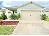 Charming single-Gathering home featuring an attached two-car garage and landscaped front yard at 103 Old Mill Pond Rd, Edgewater, FL 32141