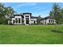Stunning modern home with a well-manicured lawn and beautiful landscaping at 1616 Turnbull Crossings Dr, New Smyrna Beach, FL 32168