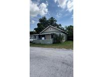 Charming one-story home featuring a covered front porch and mature landscaping at 215 Alma Ct, New Smyrna Beach, FL 32168