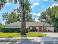 Well maintained single story home featuring a red front door, mature landscaping, and a lush green lawn at 2338 Tuscarora Trl, Maitland, FL 32751