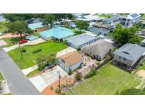 This aerial view shows the proximity to the water, as well as multiple buildings and lush green grass at 235 Randle Ave, Oak Hill, FL 32759