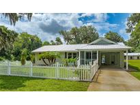 Charming single-story home with white picket fence and well-manicured lawn, evoking a sense of classic American charm at 2360 Mooneyham Dr, New Smyrna Beach, FL 32168