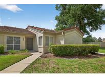 Inviting single-story home with a lush front lawn, complemented by a charming walkway to the front door at 258 W Sabal Palm Pl # 22, Longwood, FL 32779