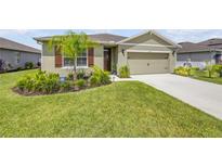 Inviting single-story home featuring a lush green lawn, well-manicured landscaping, and a charming front entrance at 2731 Neverland Dr, New Smyrna Beach, FL 32168