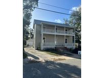Two-story home featuring double porches, neutral siding, and a metal roof at 306 Murray St, New Smyrna Beach, FL 32168