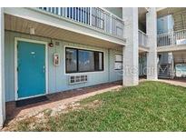 Exterior of condo with grassy area and a teal front door with one window that is open at 3509 S Atlantic Ave # 109, New Smyrna Beach, FL 32169