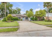 Charming single-story home with a well-maintained lawn, a light blue door and plenty of curb appeal at 357 Hearthstone Ter, Port Orange, FL 32127