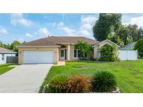 Charming single-story home featuring a well-manicured lawn, complemented by lush landscaping and a two car garage at 505 Sandale Ct, Deland, FL 32724