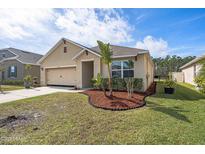 Charming single-story home featuring a well-maintained lawn, tropical foliage, and an attached two-car garage at 5263 Bear Corn Run, Port Orange, FL 32128
