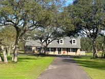Charming two-story home with mature trees and well-maintained front yard and a long, winding driveway at 5832 Michelle Ln, Sanford, FL 32771
