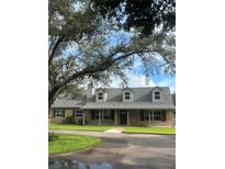 Charming one-story home with light brick, mature trees, black shutters, and inviting curb appeal at 5832 Michelle Ln, Sanford, FL 32771